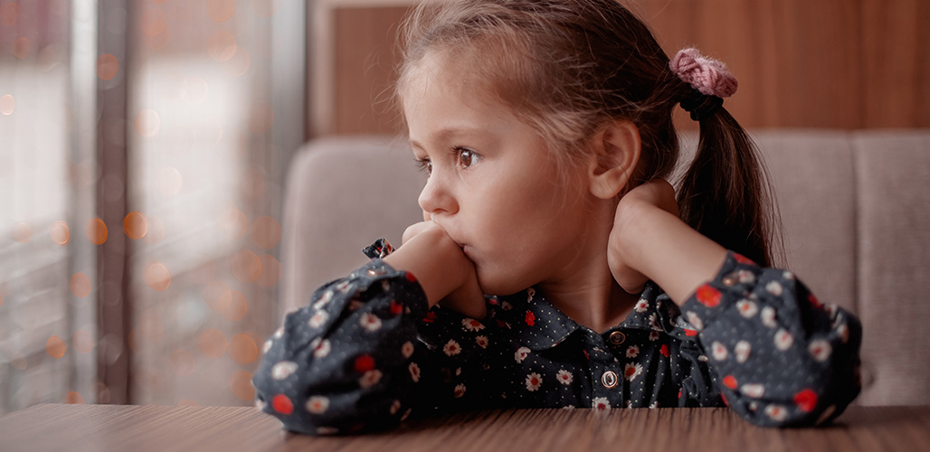 Meisje kijkt bedenkelijk uit het raam | Actueelbericht: Armoede is meer dan een lege portemonnee