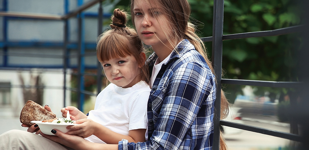 Twee kinderen eten op straat hun eten uit. | Actueelbericht: Wat iedere professional zou moeten weten over armoede