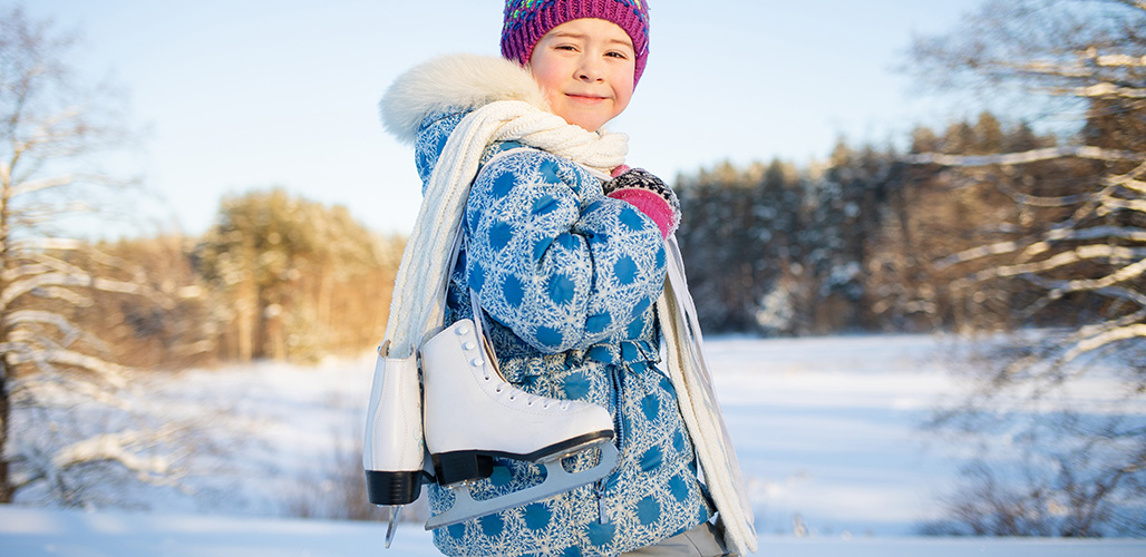 Zelfverzekerd jong meisje met kunstschaatsen op ijs in winters landschap | Actueel: Over de Olympische Winterspelen, steun en veerkracht