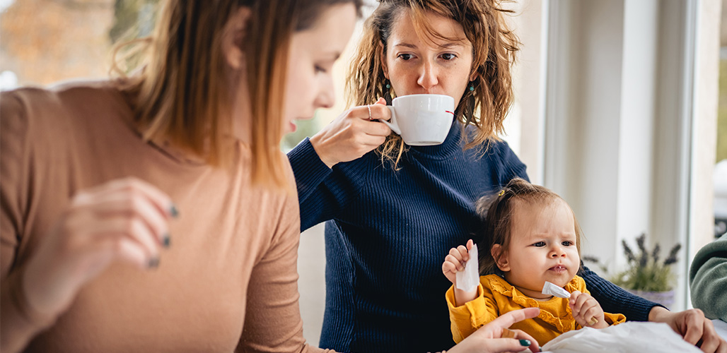 Moeder drinkt koffie met kindje op schoot | Actueelbericht: Hoe ondersteun je (aanstaande) ouders met een licht verstandelijke beperking?