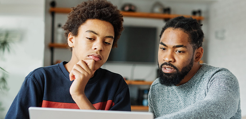 Tiener krijgt advies bij het bekijken van een internetsite op zijn laptop | Actueelbericht: Nieuw platform Jeugdtrauma.nl