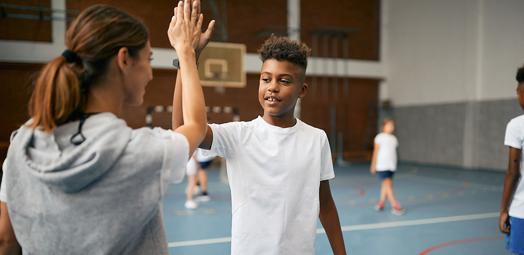 Coach geeft high five aan een van haar speelsters ter motivatie | Actueelbericht: Wegwijzer mentale gezondheid: voor buurtsportcoaches