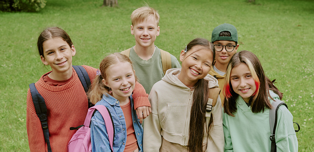 6 zelfverzekerde brugklasser buiten op het gras | Actueelbericht: Wat draagt bij aan veerkracht van kinderen? 