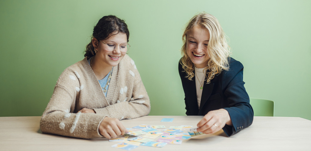 Wolkenkaarten worden door 2 vrouwen gebruikt. Kaarten liggen open op tafel. | Wolkenkaarten.nl - Martijn van Leeuwen (fotograaf)