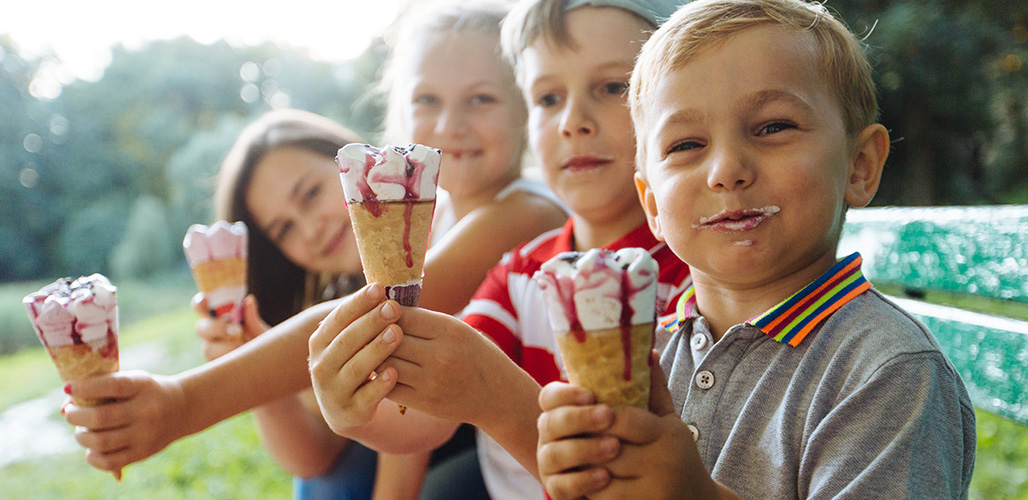 Zomertips! - Kinderen genieten van hun ijsje in het park op een bankje