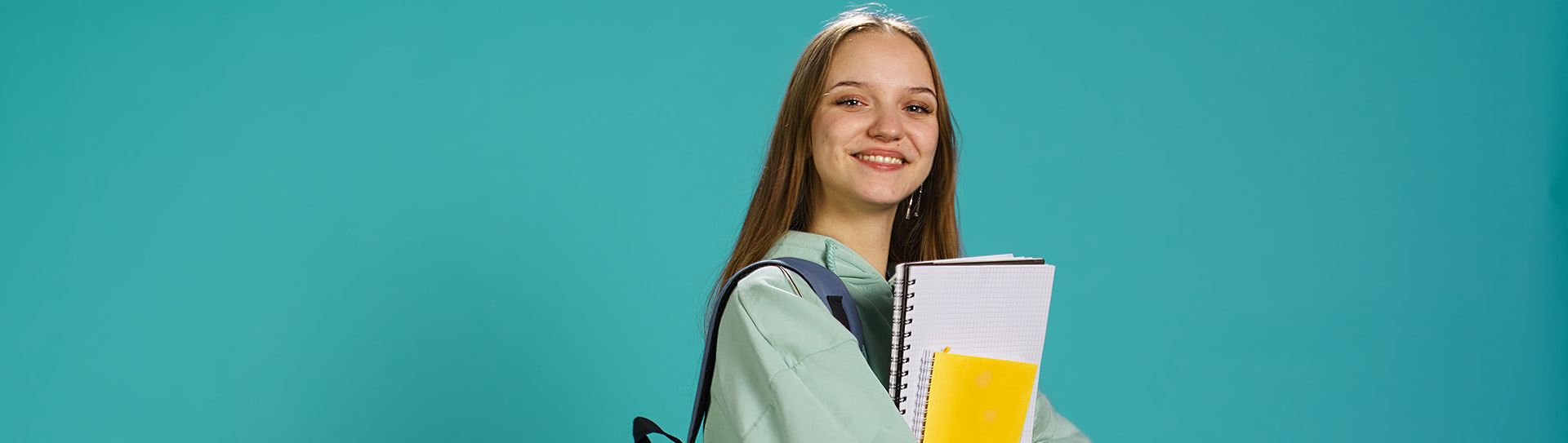 Studente houdt studiemateriaal vast. Groene achtergrond