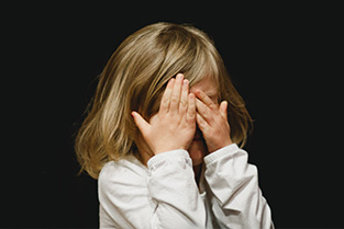 Kindje met handen voor haar ogen