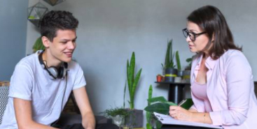 tips voor een goed gesprek - luisterende professional maakt notities terwijl jongen praat