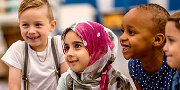 Doe de meldcode test en kom er achter wat jij al weet - vrolijke kinderen luisteren aandachtig naar docent.